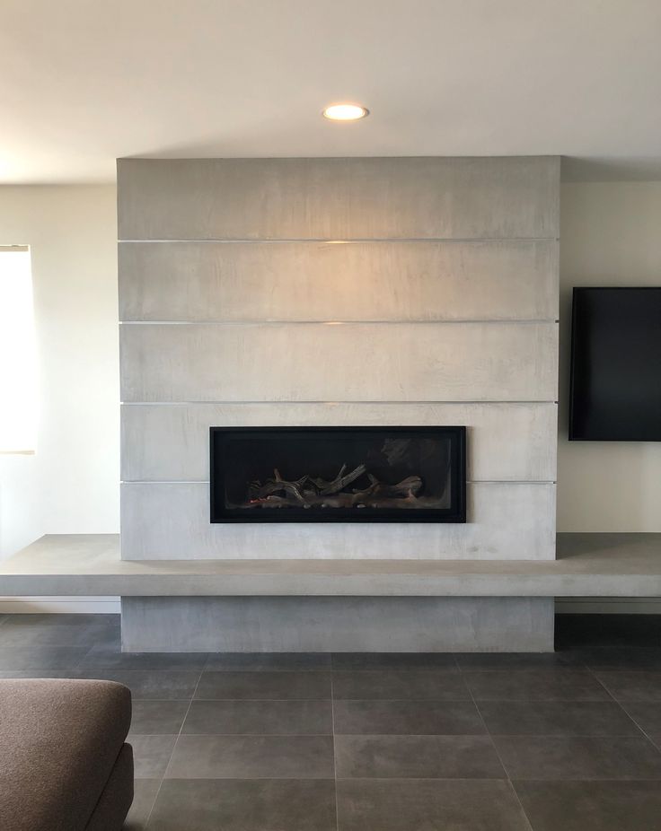 a living room with a large fireplace and flat screen tv on the wall above it