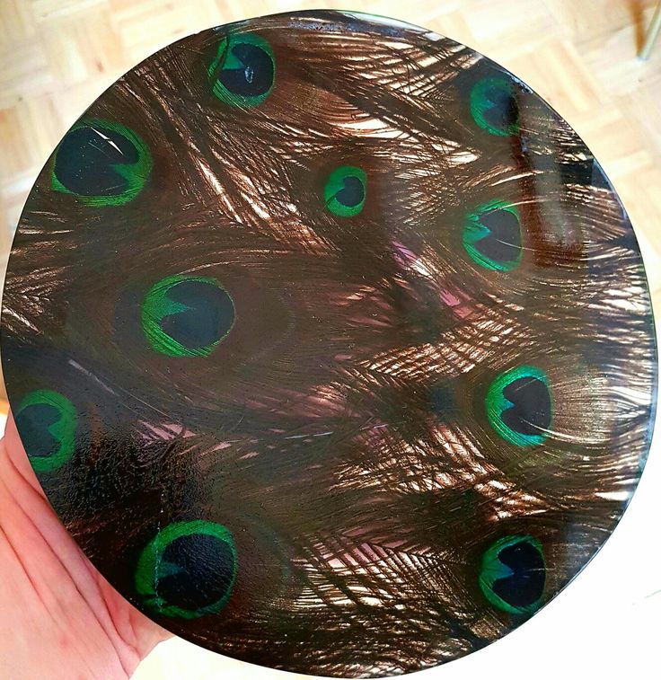 a person holding a plate with peacock feathers on it