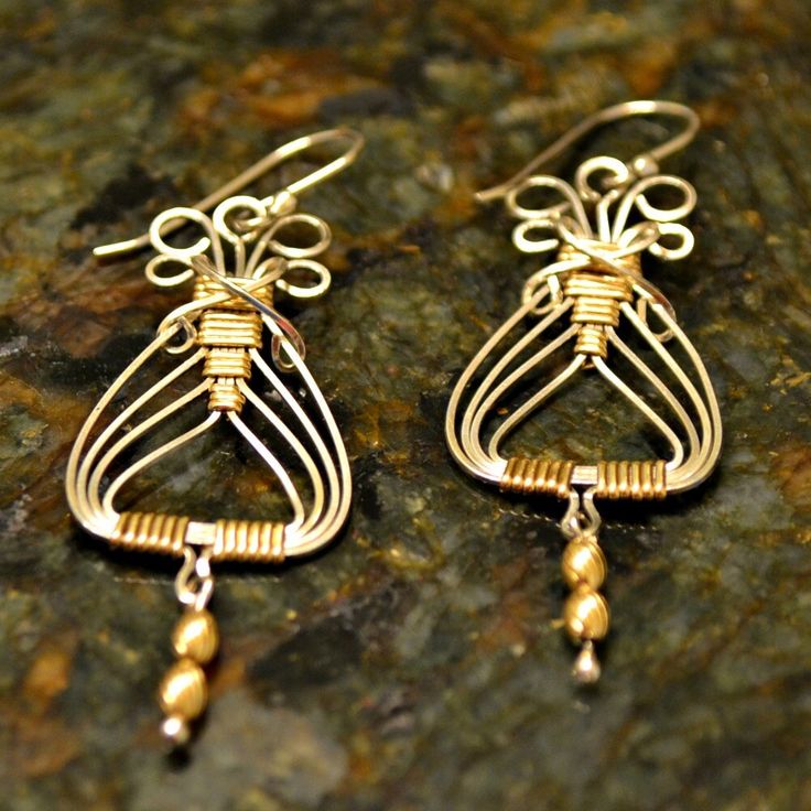 "Sterling Silver and 14K gold filled wire combine with wire wrapping to make these Egyptian style earrings. Lightweight on your ears but sturdy. Handmade. Average time to make these is 1-2 days. The dangling beads are also 14K gold filled and the earrings hang 2-3/4\" from the finest sterling earwires that come with rubber earnuts. Interested in a matching bracelet? see this lisitng: http://www.etsy.com/listing/77246374/egyptian-bracelet-wirewrapped-sterling I also make a matching pendant. Conta Elegant Wire Wrapped Wrap Earrings In Brass, Gold Wire Dangle Earrings, Gold Bohemian Wire Jewelry, Bohemian Yellow Gold Wire-wrapped Earrings, Bohemian Gold Wire Jewelry, Elegant Gold Wire Wrapped Beaded Earrings, Bohemian Yellow Gold Wire Wrapped Earrings, Elegant Gold Wire Wrapped Wrap Earrings, Wire Wrapped Brass Chandelier Earrings