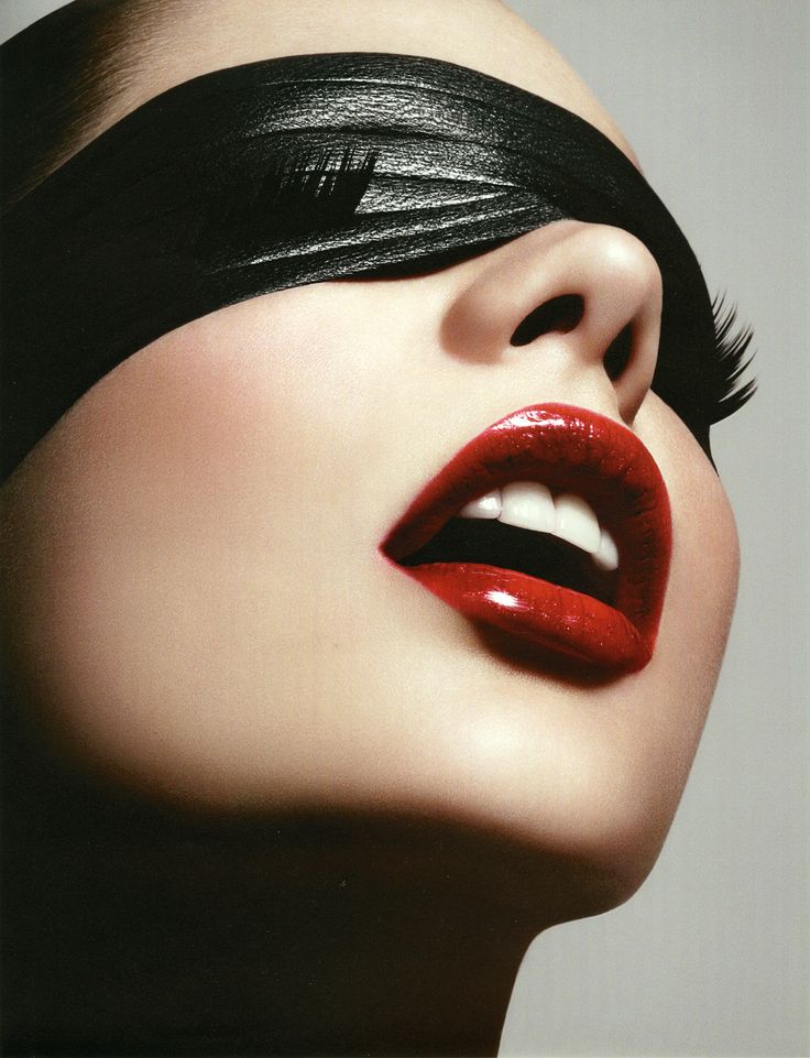 a woman with black hair and red lipstick has her eyes closed to the side as she is