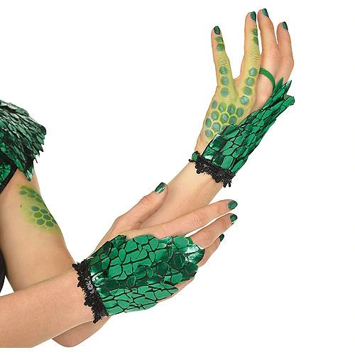 a woman wearing green and black gloves holding her hands out to the side with painted nails