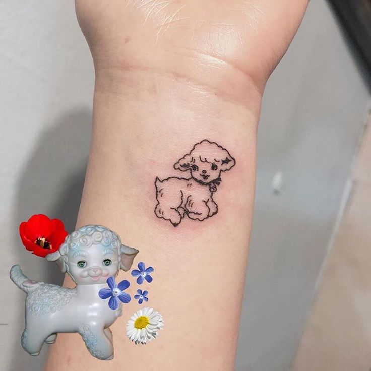 a small tattoo on the wrist of a girl with a dog and flower in it