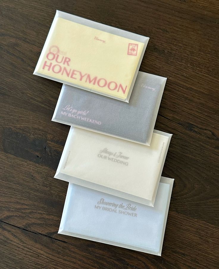 three envelopes are stacked on top of each other with the words our honeymoon printed on them