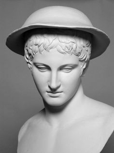 a white bust wearing a hat on top of it's head