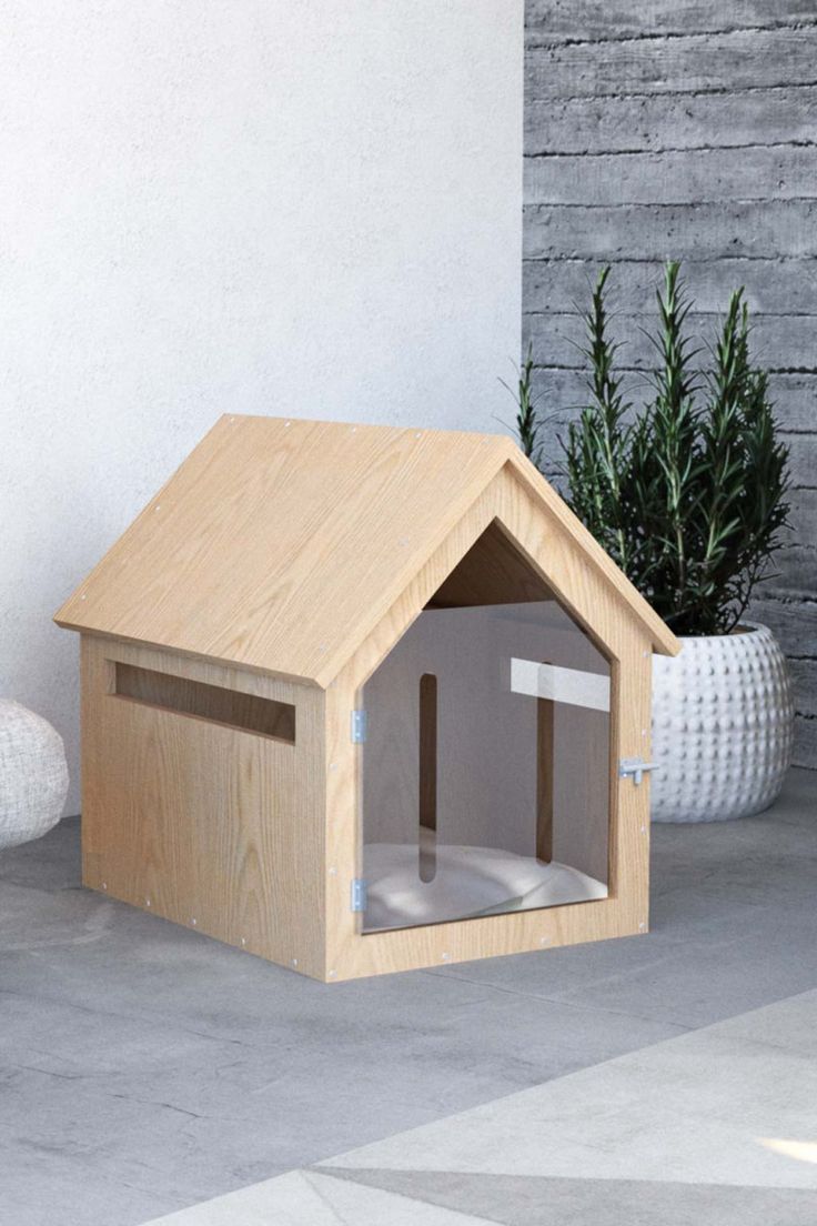 a wooden dog house sitting next to a plant