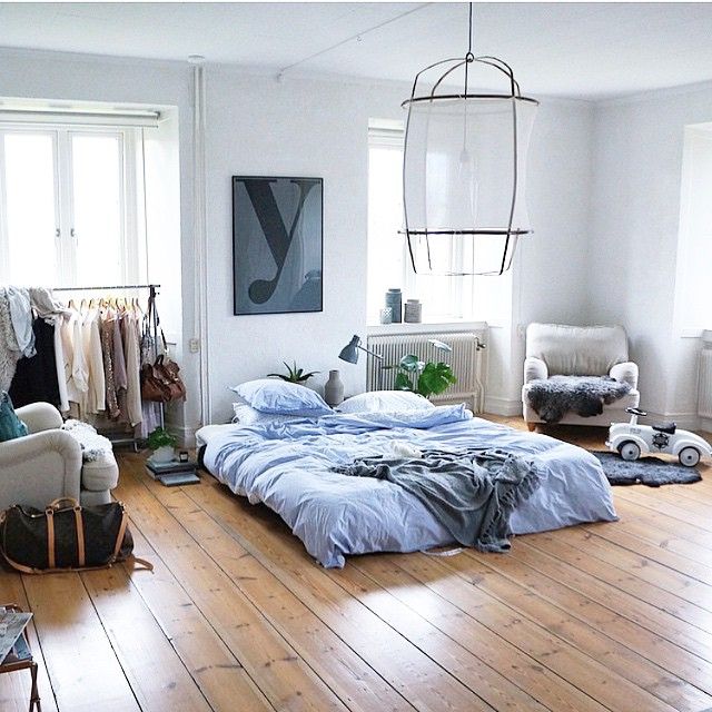 a bed sitting on top of a wooden floor in a bedroom