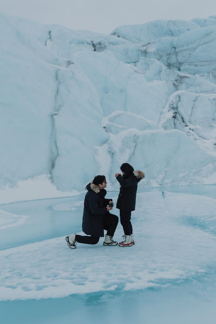 two people are sitting on an ice floet