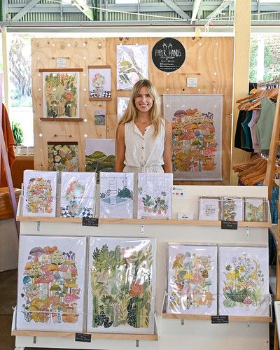 a woman standing in front of a table with cards and pictures on it's sides