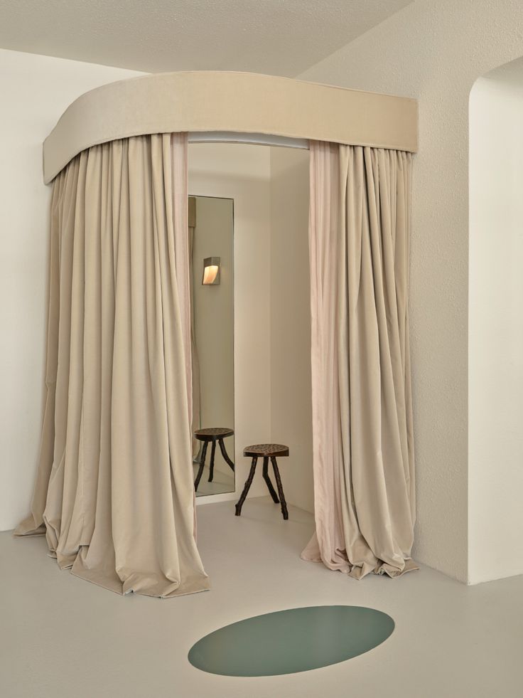 a room with a round bed and drapes