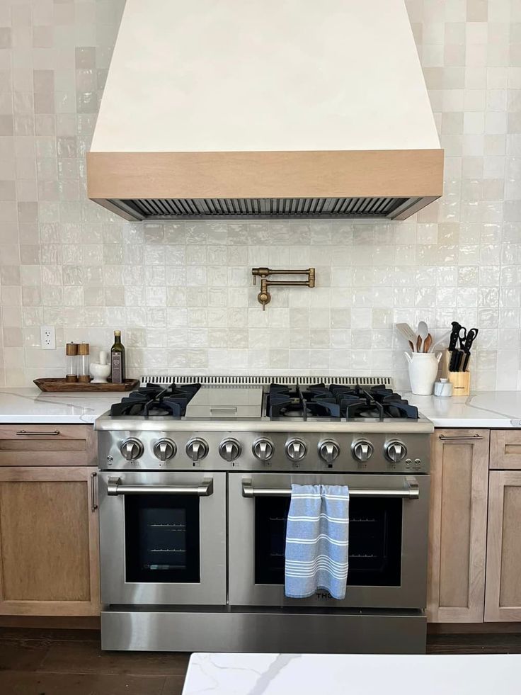 a stove top oven sitting inside of a kitchen next to wooden cabinets and counter tops