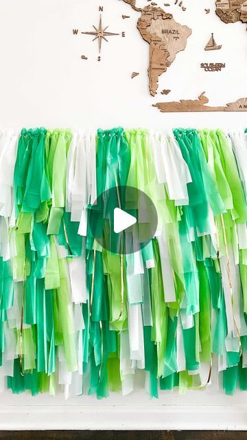 green and white streamers hanging on the wall in front of a world map,