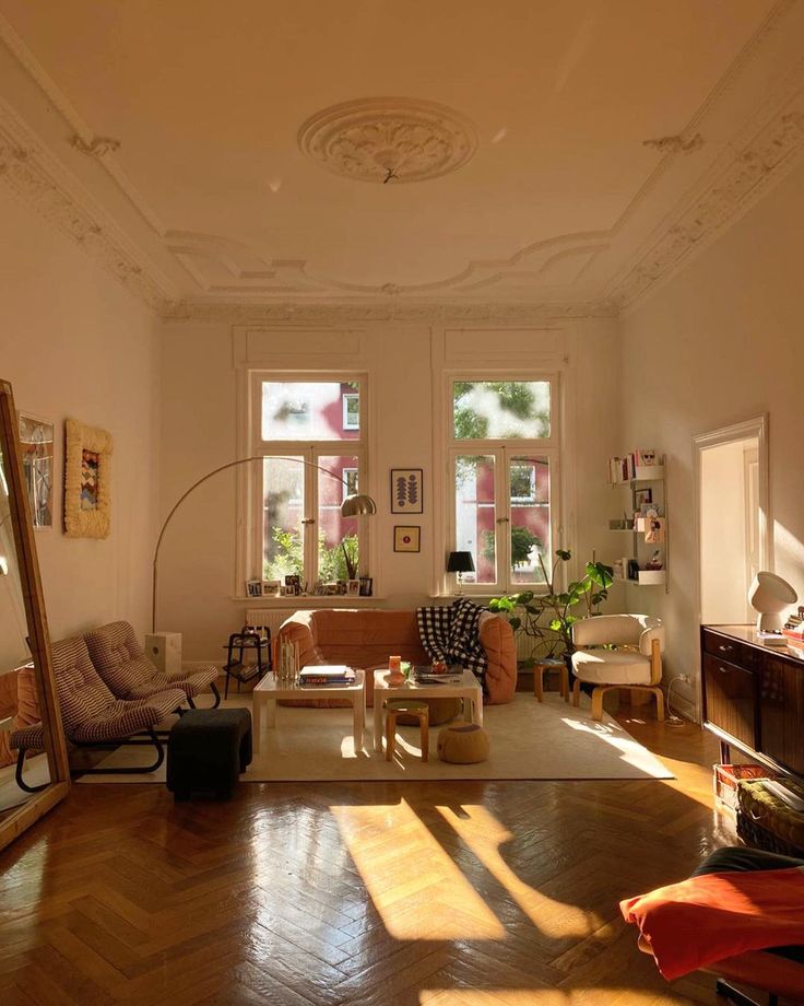 a living room filled with lots of furniture next to two windows and a wooden floor