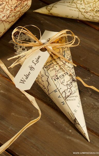 some paper cones tied with twine on top of a wooden table next to maps