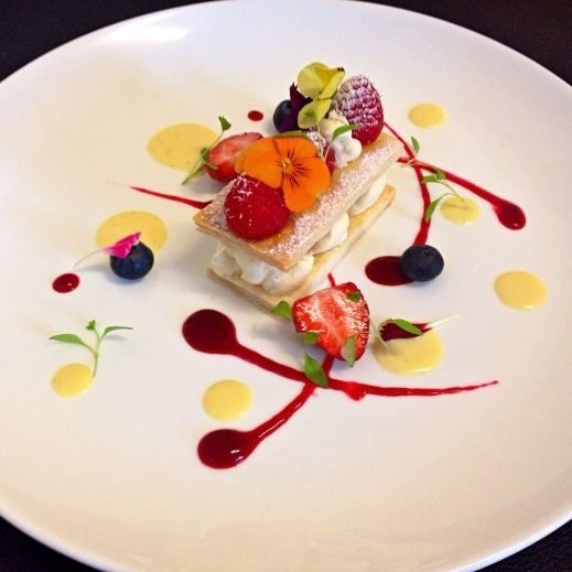 a white plate topped with dessert and fruit