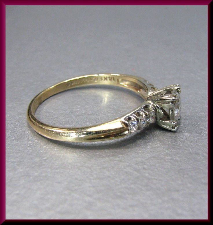 Relaxed refinement illustrates this 1940's engagement ring set in 14k yellow gold. A single .40 ct transitional cut diamond is set in the center with a G color and VS2 clarity. With 3 round diamonds on each side uplifting pivotal piece presents unyielding appeal. ER 522M SIX MONTH LAY-AWAY AVAILABLE - PLEASE CONTACT ME TO SET UP A PLAN Vintage Oval Diamond Ring With Single Diamond, Vintage Oval Diamond Ring With Single Stone, Vintage Single Diamond Jewelry With Round Band, Vintage Yellow Gold Diamond Ring With Diamond Cut, Vintage Yellow Gold Diamond Ring With Single Diamond, Vintage Yellow Gold Diamond Ring With Single Stone, Vintage Yellow Gold Diamond Cut Diamond Ring, Classic Round Cut Diamond Ring Stamped 14k, Vintage Yellow Gold Rings With Diamond Accents