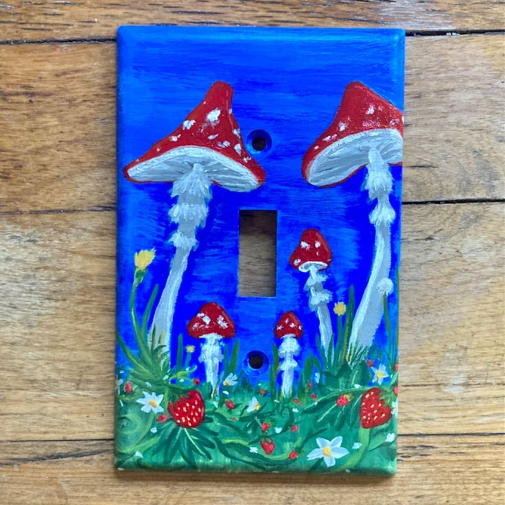 a light switch cover with mushrooms painted on it