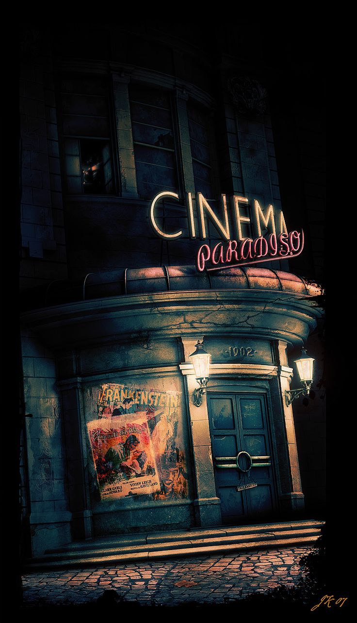 an advertisement for a movie theater on the side of a building at night with neon lights