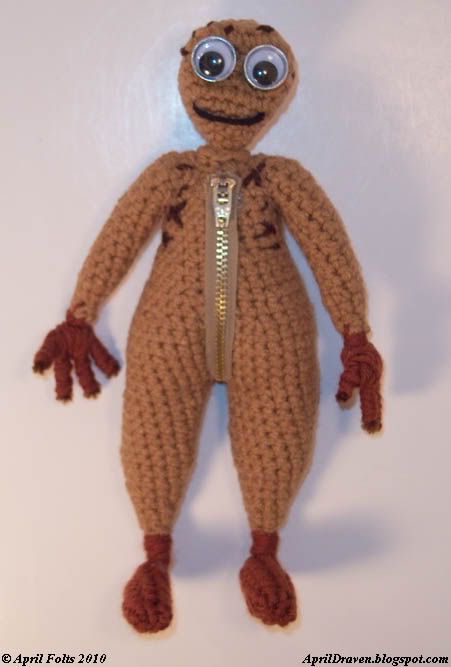 a crocheted stuffed animal with big eyes and legs, wearing a zippered jacket