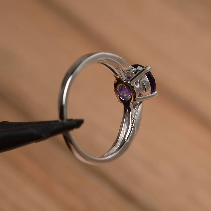 It is a natural amethyst ring. The main stone is 7mm*7mm round cut, weight about 1.25 carats. The basic metal is sterling silver and plated with rhodium. To change the metal to a solid gold (white/rose) or platinum is also available, please ask for a quotation if you want. You can also go to my shop Home for more elegant rings: https://www.etsy.com/shop/godjewelry?ref=hdr_shop_menu More amethyst rings: https://www.etsy.com/shop/godjewelry?ref=seller-platform-mcnav&section_id=20709248 Customi Elegant Purple Solitaire Birthstone Ring, Classic Amethyst Cubic Zirconia Promise Ring, Elegant Purple Birthstone Ring, Classic Amethyst Round Cut Birthstone Ring, Classic Amethyst Birthstone Ring With Round Cut, Amethyst Birthstone Ring With Center Stone In White Gold, Elegant Amethyst Birthstone Ring With Round Stone, White Gold Amethyst Birthstone Ring With Center Stone, Promise Ring With Tension Setting