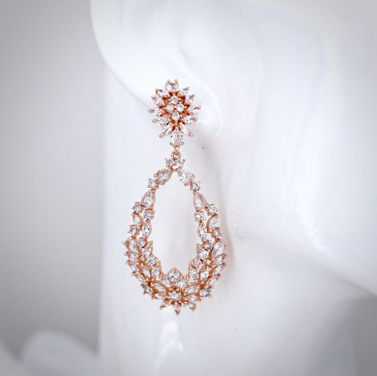 Bold and beautiful, this pair of bridal earrings will add a touch of sophistication to any wedding gown or formal ensemble. Adorned with flawlessly faceted cubic zirconia that capture the light in a dazzling array of sparkles, the earrings are rhodium/rose gold plated for a bright finish which enhances the intricate detailing and conveys a modern take on old elegance. Length: 2.5" (approx. 6.3cm). Width: 1" (approx. 2.5cm). Weight: 10g. Available in Silver and Rose Gold finishes. To make your ch Cubic Zirconia Bridal Earrings, Bold And Beautiful, Bridal Earrings, Wedding Gown, Rose Gold Plates, Gold Finish, Wedding Jewelry, Wedding Gowns, Cubic Zirconia