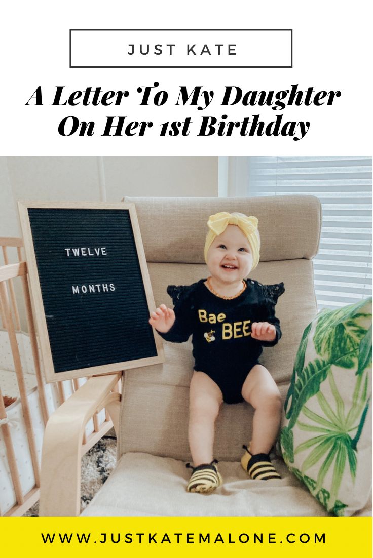 a baby sitting in a rocking chair holding a sign