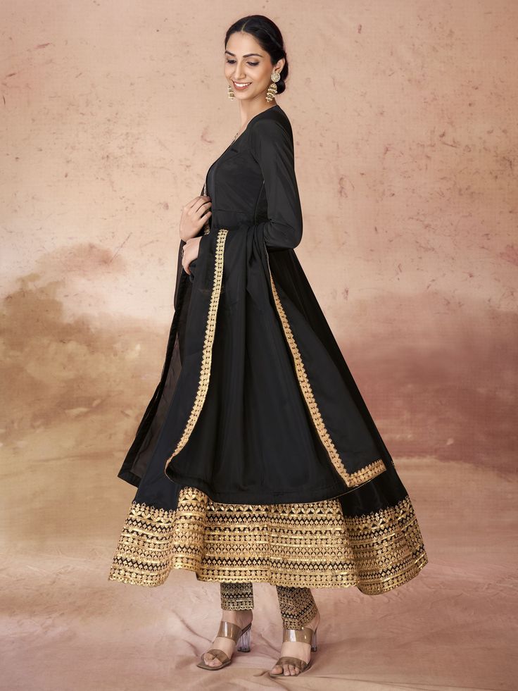 This elegant black suit features intricate embroidery and sequin work on the border, adding a touch of glamour to your look. The crepe fabric is both luxurious and comfortable, ensuring you feel confident and stylish at any occasion.
This anarkali suit set includes a fully stitched pant in a matching black color, as well as a similar color organza dupatta with designer lace work. The pants also have embroidered and sequin details, creating a cohesive and sophisticated ensemble. Available in size Festive Black Salwar Kameez With Sheer Dupatta, Festive Black Chanderi Salwar Kameez, Black Lehenga With Dabka Work For Festive Occasions, Black Bollywood Sharara With Sheer Dupatta, Black Lehenga For Eid Formal Occasion, Black Festive Sets With Sheer Dupatta, Black Unstitched Suit With Zari Work For Navratri, Black Anarkali Unstitched Chanderi Suit, Black Chanderi Anarkali Unstitched Suit