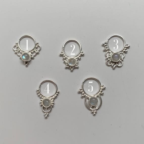 These are soooooo pretty. Made is 925 sterling silver with tribal details, set with a moonstone. The rings are all 1cm (.40”) in diameter. The wire is 20 gauge.Back in open on the stone so light shines through, and the stones have a beautiful rainbow shimmerEach piece is made BY HAND so may vary sightly from the photoOne of the images contains numbers to specify which you would like from the drop down menu. Silver Goddess, Grass Valley, Septum Piercing, Nose Rings, Nose Ring Stud, Sterling Silver Flowers, Beautiful Rainbow, Smokey Quartz, Silver Flowers