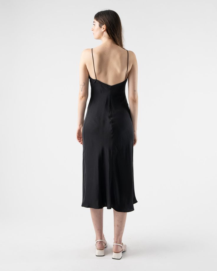 Loretta Midi Slip Dress in Black from Kamperett. Silk mid-calf slip dress with spaghetti straps. Featuring a straight cut neckline and a V at the back. Designed to be layered under the Meiere Midi Dress. 100% Silk Charmeuse Matte side out Sustainably and ethically made in California Sam is 5'8 and wearing size small Size Bust Waist Hip Length XS 30" 28" 42" 46" S 32" 30" 44" 46" M 34" 32" 46" 46" L 36" 34" 50" 46" XL 38" 36" 52" 47" 1X 40" 38" 54" 47" Kamperett Kamperett is a womenswear line fro Evening Midi Dress With Delicate Straps Fitted, Elegant Midi Slip Dress With Adjustable Straps, Silk Midi Dress With Spaghetti Straps For Evening, Elegant Slip Dress With Spaghetti Straps For Cocktail, Date Night Slip Dress With Straight Neckline, Elegant Cocktail Slip Dress With Spaghetti Straps, Evening Dress With Delicate Straps And Straight Neckline, Black Backless Bias Cut Slip Dress, Backless Midi Dress With Adjustable Straps For Evening