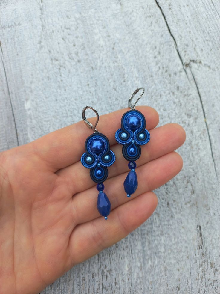 The elegant blue small soutache earrings will perfectly accentuate your look. They will complement your everyday outfits and evening gowns.  Ready to ship!      Soutache earrings are very light! And it is their great benefit! You will not feel them in your earlaps despite their big size!      The earrings are made in soutache technique using a soutache cord, glass and crystal beads. The fixture is rhodium-plated and will not cause allergy.      If you would like to have these earrings in a different color, send me a personal message and we will talk it through. A bracelet or a necklace can also be made to complement these earrings. Feel free to contact me and we will discuss your wishes and requests.      See the other jewelry from my store. https://www.etsy.com/shop/MagicalSoutache Thank Soutache Tutorial, Boho Chic Earrings, Soutache Earrings, Soutache Jewelry, Chic Earrings, Blue Jewelry, Chandelier Earrings, Big Size, Rhodium Plated