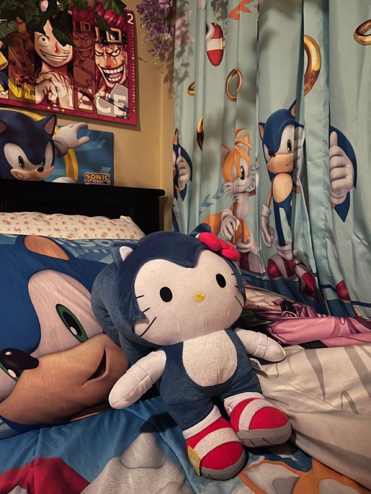 there is a stuffed animal that is laying on the bed with sonic and knuckles dolls