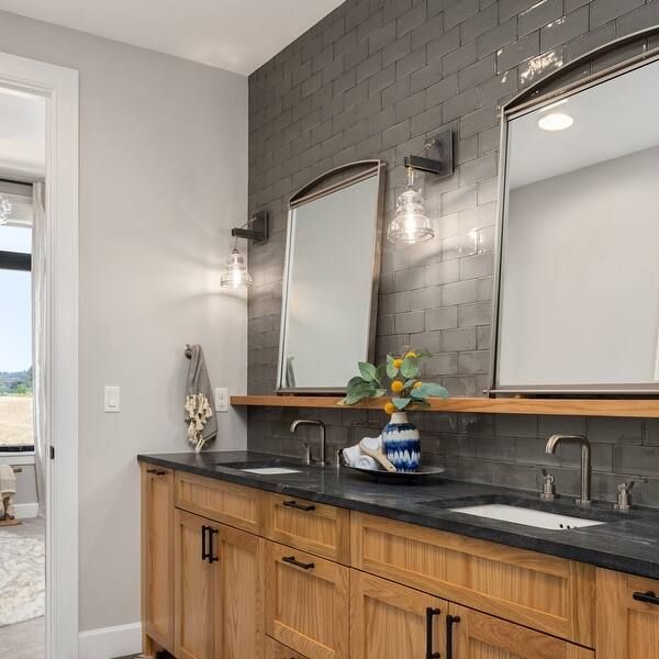 a bathroom with double sinks and two mirrors on the wall next to a door that leads to an outside patio