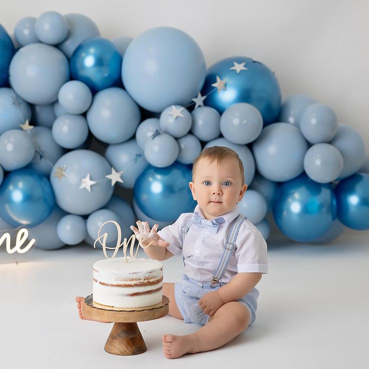 a baby sitting in front of a cake