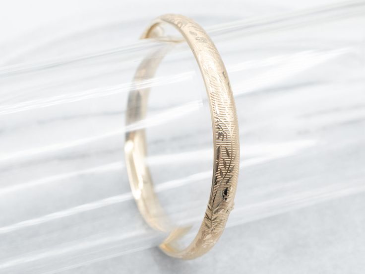 The details on this vintage 14-karat gold bangle are simply stunning! Intricate scrolling botanical designs are engraved in warm yellow gold, covering the entire bracelet. Beautiful on its own or layered with other bracelets this piece is perfect for day or evening wear.Metal: 14K Yellow GoldWidth: 6.3 mmInside Circumference: 6 1/2 InchesMarks: "JW 14K" Stamped on the inside band Elegant Engraved Bangle, Elegant Bracelet With Decorative Band For Anniversary, Classic Etched Gold Bracelet For Formal Occasions, Classic Etched Gold Bracelet, Classic Gold Bracelet With Intricate Design, Classic Formal Cuff Bracelet With Intricate Design, Etched Yellow Gold Bracelet For Anniversary, Elegant Engraved Cuff Bracelet For Formal, Elegant Engraved Cuff Bracelet For Formal Occasions