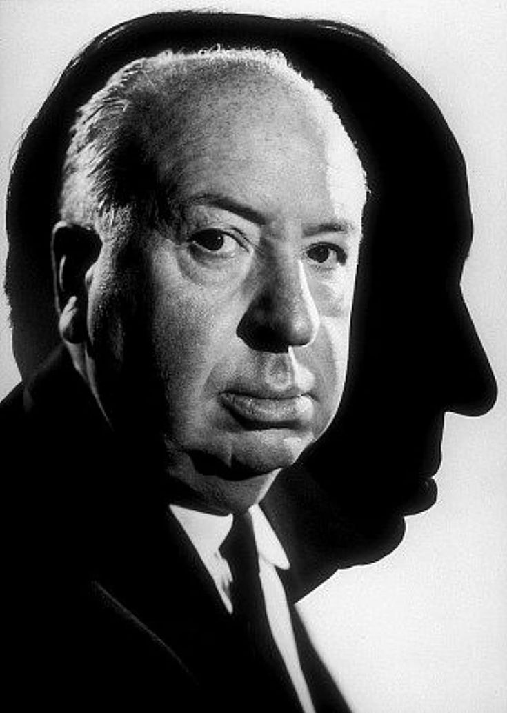 a black and white photo of a man in a suit with a hat on his head