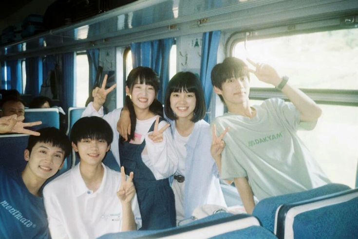 a group of young people sitting on top of a bus