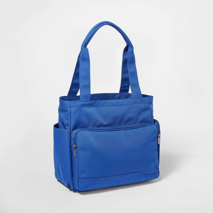 a blue handbag on a white background with the handles folded down and one side open