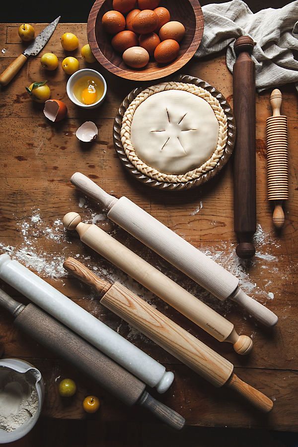 an assortment of kitchen utensils and ingredients on a wooden table, including pie