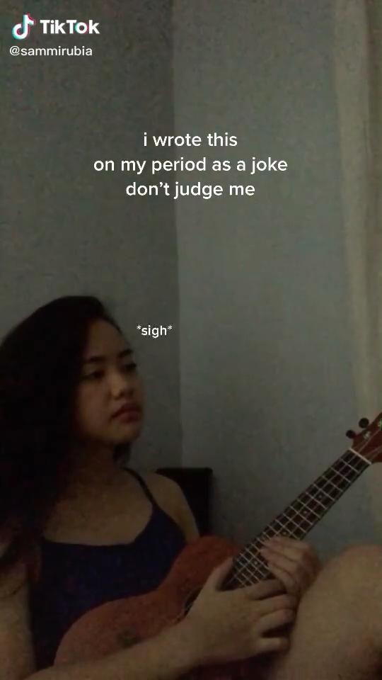 a woman sitting on a bed holding a ukulele with a quote above her