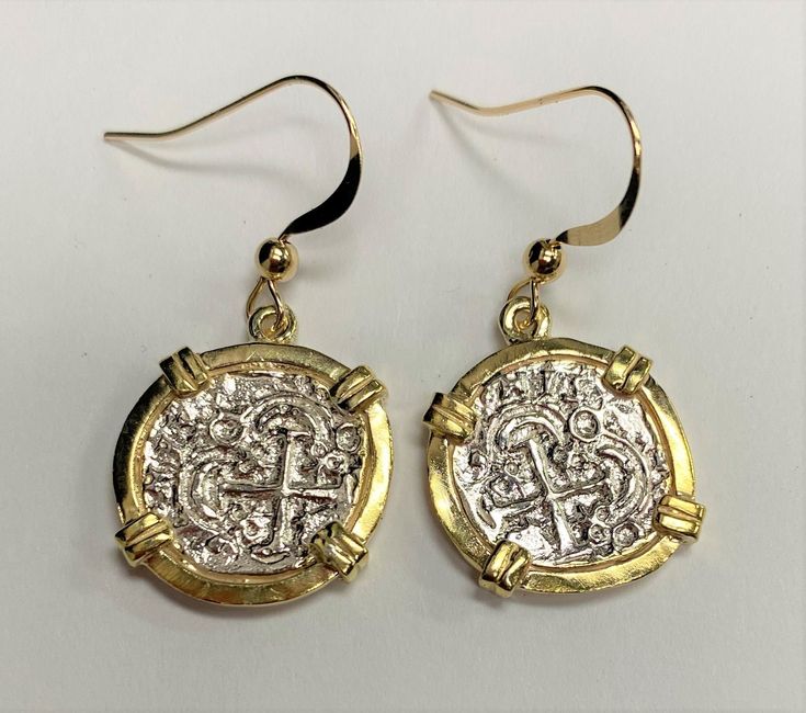 This is a museum quality model of an Atocha coin as found on the famous shipwreck Nuestra Senora De Atocha of 1622 These coins were casted with a portion of silver recovered from the shipwreck The Earrings are Clad in 14K Yellow Gold and are casted together with a 1 Reale Coin Comes with a certificate of authenticity and a gift pouch. Dimensions: approx. 1.8 H x 1.7 W cm each not including Shepherd Hook Hallmarked Coin-shaped Earrings Gift, Silver Round Byzantine Earrings, Symbolic Coin-shaped Collectible Jewelry, Symbolic Collectible Coin Jewelry, Tarnish Resistant Byzantine Round Jewelry, Tarnish Resistant Byzantine Jewelry, Engraved Coin Earrings For Gift, Nickel Free Coin-shaped Sterling Silver Earrings, Nickel-free Coin-shaped Sterling Silver Earrings