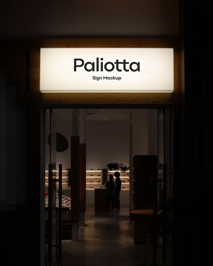 two people standing in front of the e - shop at night with their back lights on