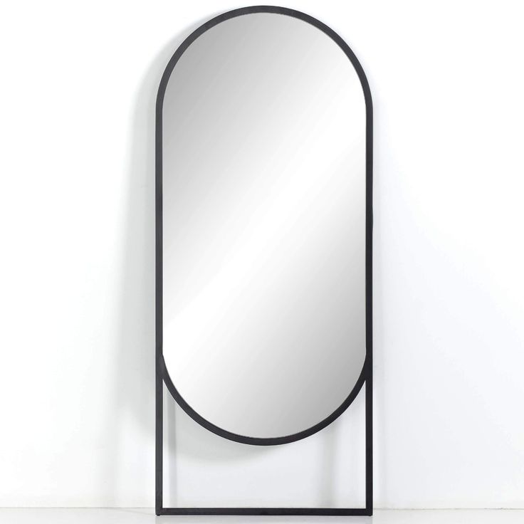 a mirror that is sitting on top of a shelf in front of a white wall