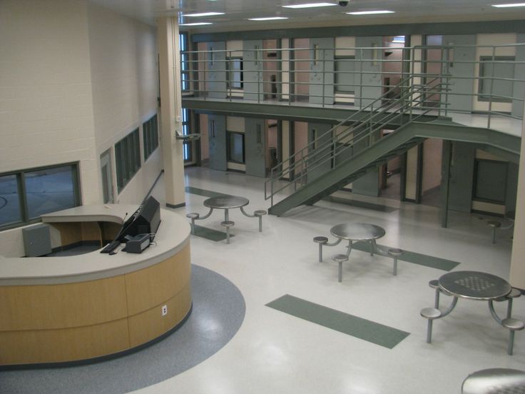 the inside of a building with benches and tables in front of it, along with stairs leading up to second floor