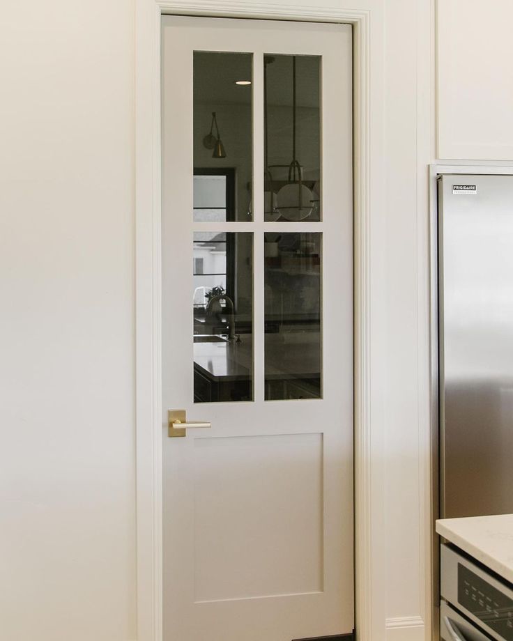 a white door in a kitchen next to an oven