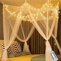 a bed with white mosquito netting and lights on the headboard, along with a remote control