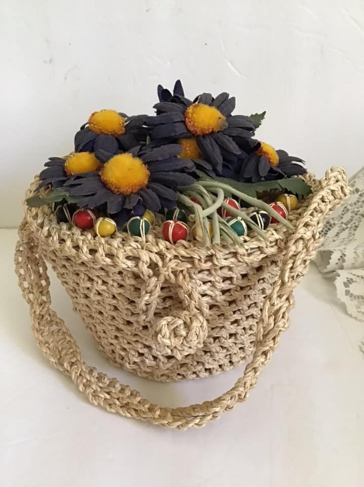 "Vintage 1950's tightly woven Raffia straw handbag. Has colorful wood beads and flowers on the lid. The maker is *Bags By Garay*. Made in Japan. Is fabric lined. *MORE INFORMATION BELOW* CONDITION: I note one small stain on the inside of the lid at the bottom left edge (SEE PIX). MEASURES: Height-4 1/2\" Circumference-21\" Handle drop-5 1/2\" *WE APOLOGIZE~BUT WE NO LONGER SHIP TO GERMANY, ITALY OR SPAIN. IF ORDERS COME IN FROM GERMANY, ITALY OR SPAIN, WE WILL HAVE TO CANCEL THEM AND REFUND YOUR Handmade Vintage Straw Bag, Vintage Brown Woven Straw Bag, Vintage Handwoven Straw Bag, Vintage Basket Straw Bag, Vintage Summer Straw Bag In Natural Color, Vintage Straw Bag For Everyday Use, Handmade Vintage Straw Basket Bag, Vintage Natural Straw Bag, Vintage Straw Basket Bag