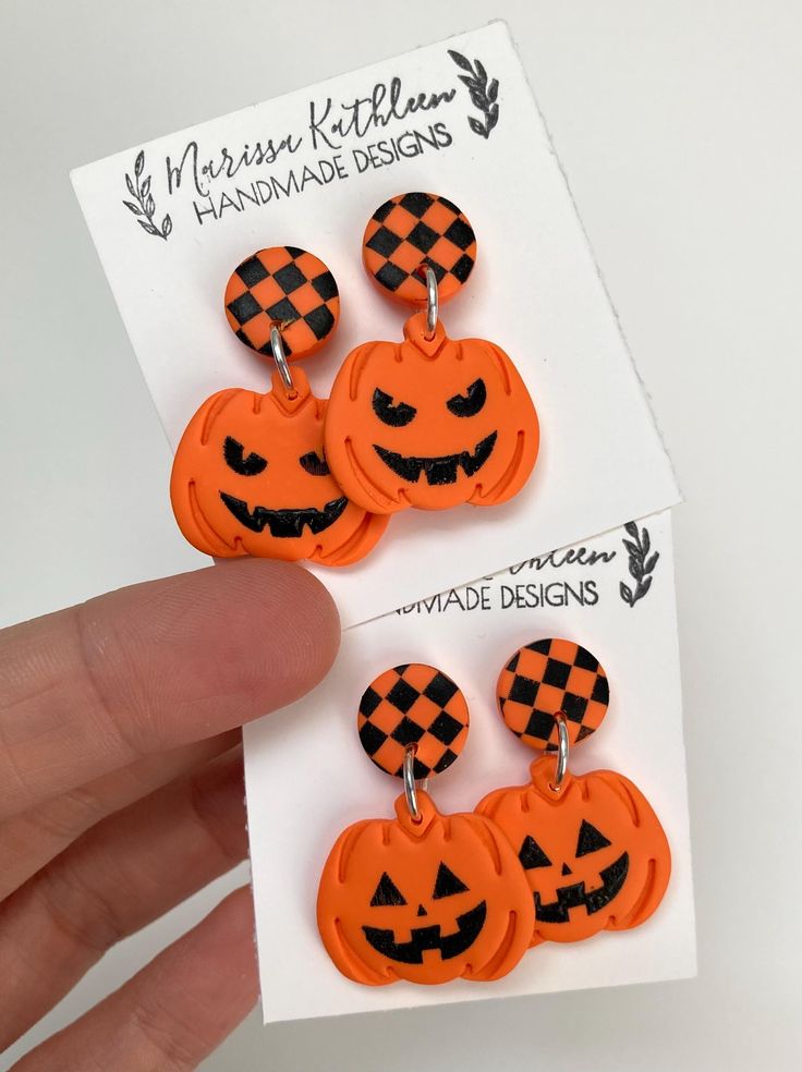 three orange and black jack - o'- lantern earrings with checkered pumpkin faces