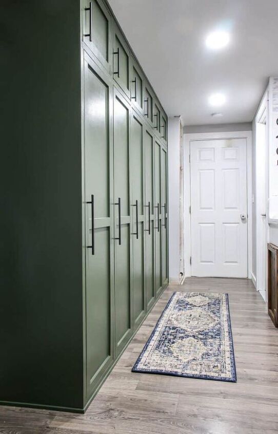 a hallway with green lockers and a rug on the floor in front of it