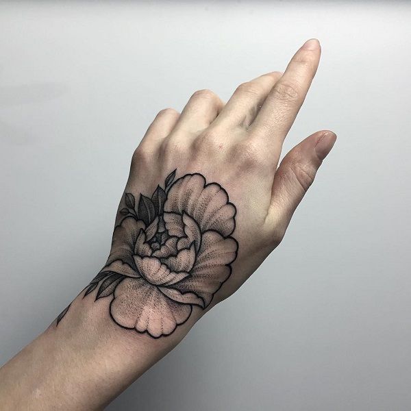 a person's hand with a flower tattoo on it