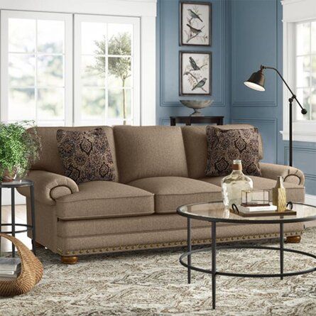 a living room with blue walls and furniture on the floor, including a coffee table