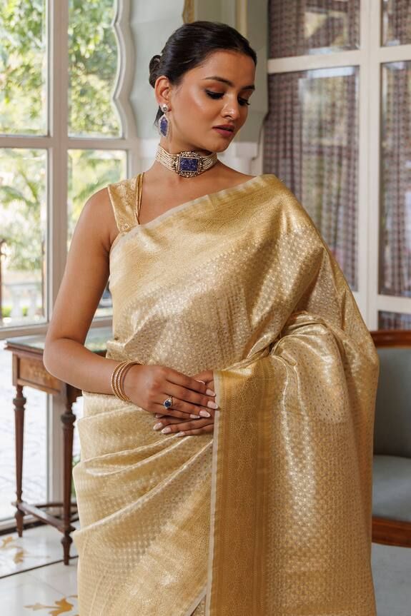 Gold banarasi silk saree with zari woven bloom motifs all over. Comes with an unstitched blouse piece. - Aza Fashions Katan Silk Pre-draped Saree With Zari Weaving For Navratri, Navratri Katan Silk Saree With Zari Weaving, Elegant Lehenga For Puja And Navratri, Elegant Raw Silk Blouse With Self Design, Elegant Slub Silk Lehenga For Diwali, Elegant Self Design Blouse For Navratri, Festive Wedding Blouse With Zari Weaving, Elegant Art Silk Pre-draped Saree For Festivals, Designer Wear Katan Silk Blouse With Zari Weaving